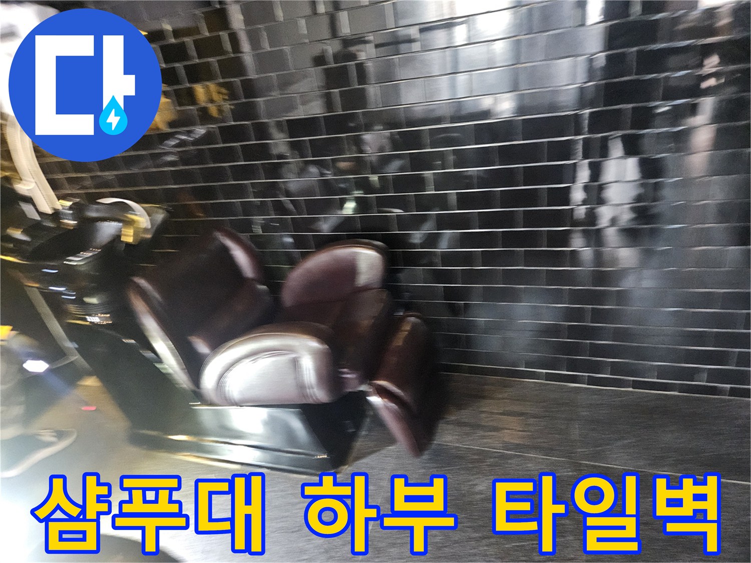 미용실 내부 샴푸대와 검은색 벽면 타일
