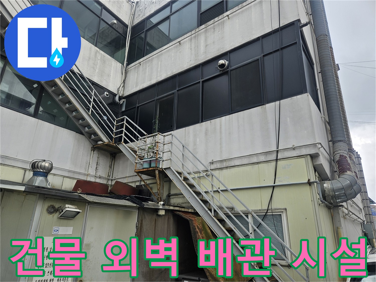 상가 건물 외벽의 금속 난간과 노출된 배관 상세