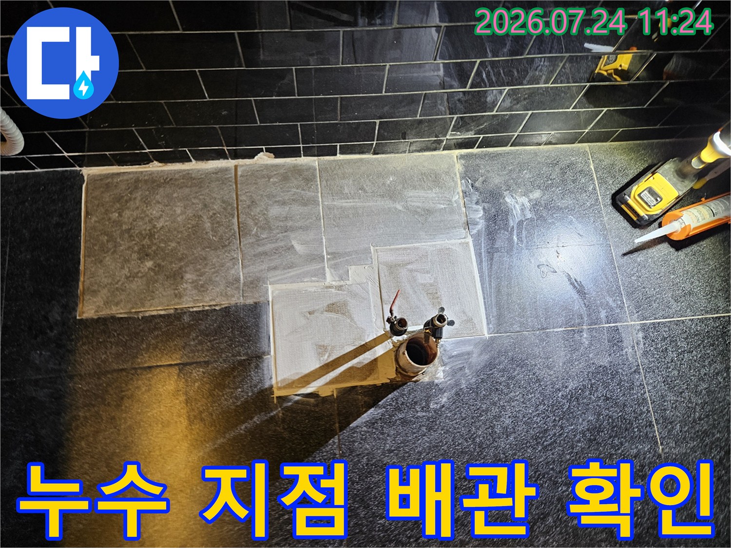 상가 내부에서 타일을 제거하고 노출된 온수 배관을 세밀하게 점검하는 모습