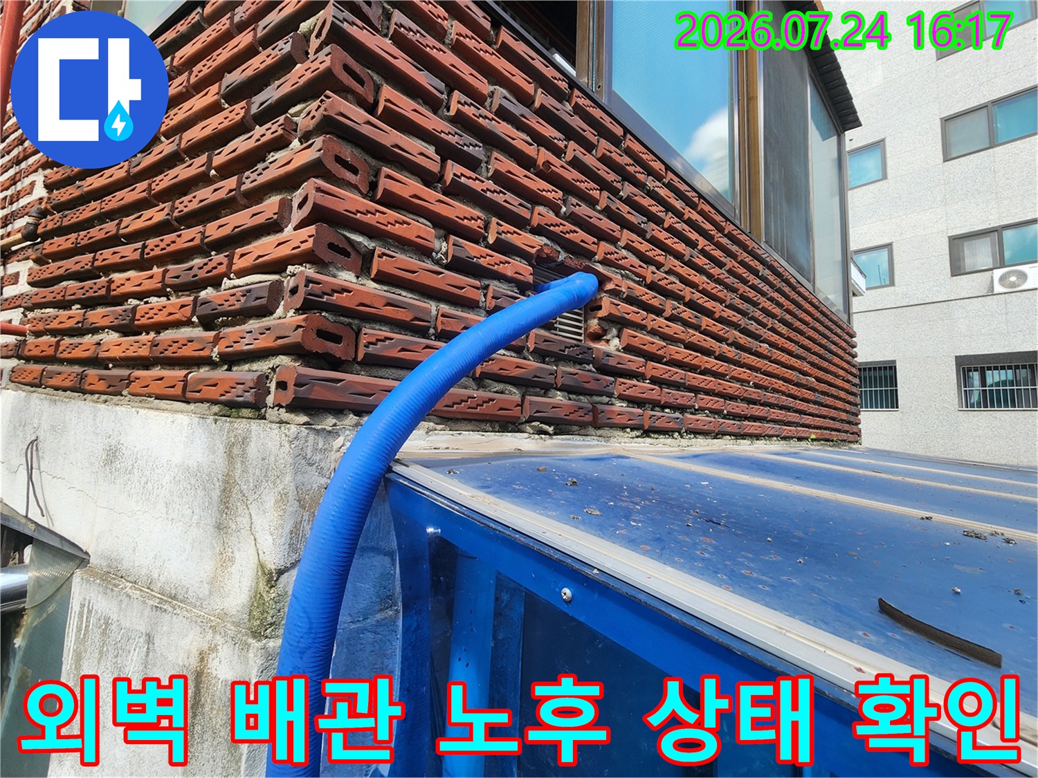 노출된 파란색 수도 배관과 벽면의 마감재를 점검하는 모습