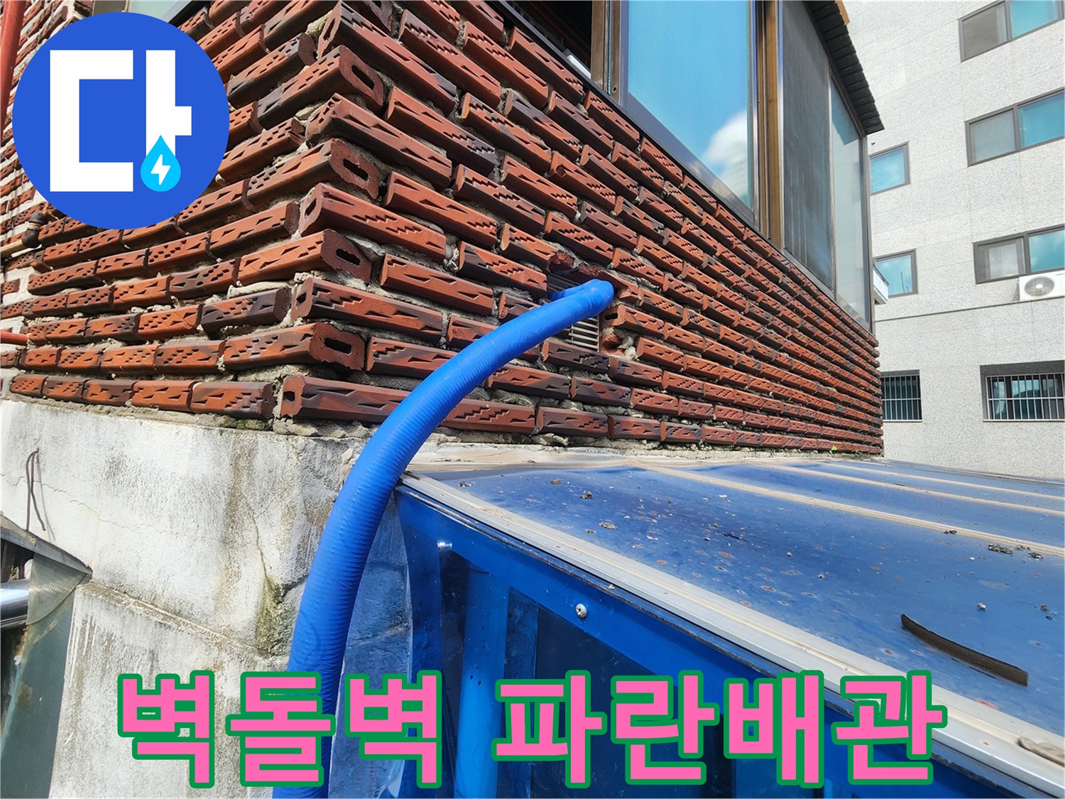 붉은 벽돌 외벽과 파란색 보온재가 씌워진 배관