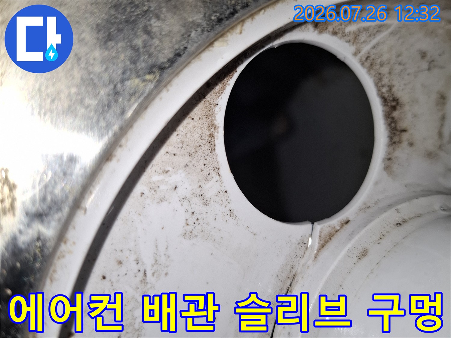 흰색 플라스틱 마감재 중앙에 뚫린 원형의 배관 통로-슬리브-부분 사진