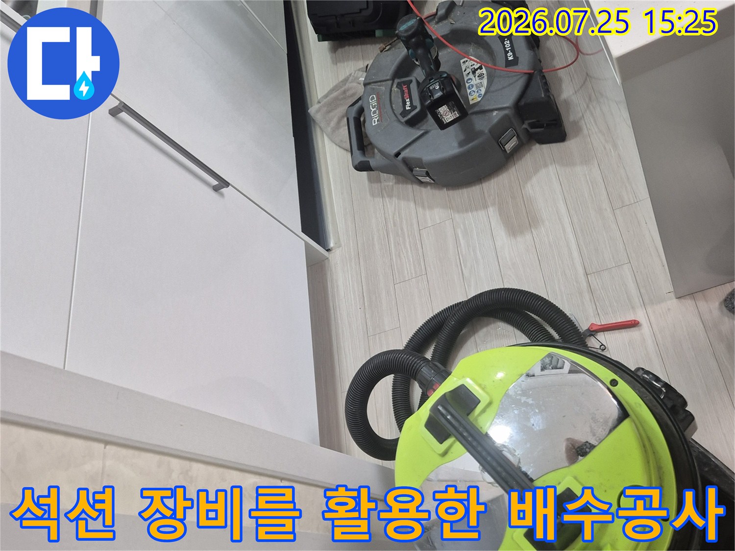 싱크대 하부장에서 석션기를 동원하여 배수구 내부의 이물질을 제거하는 초기 공정