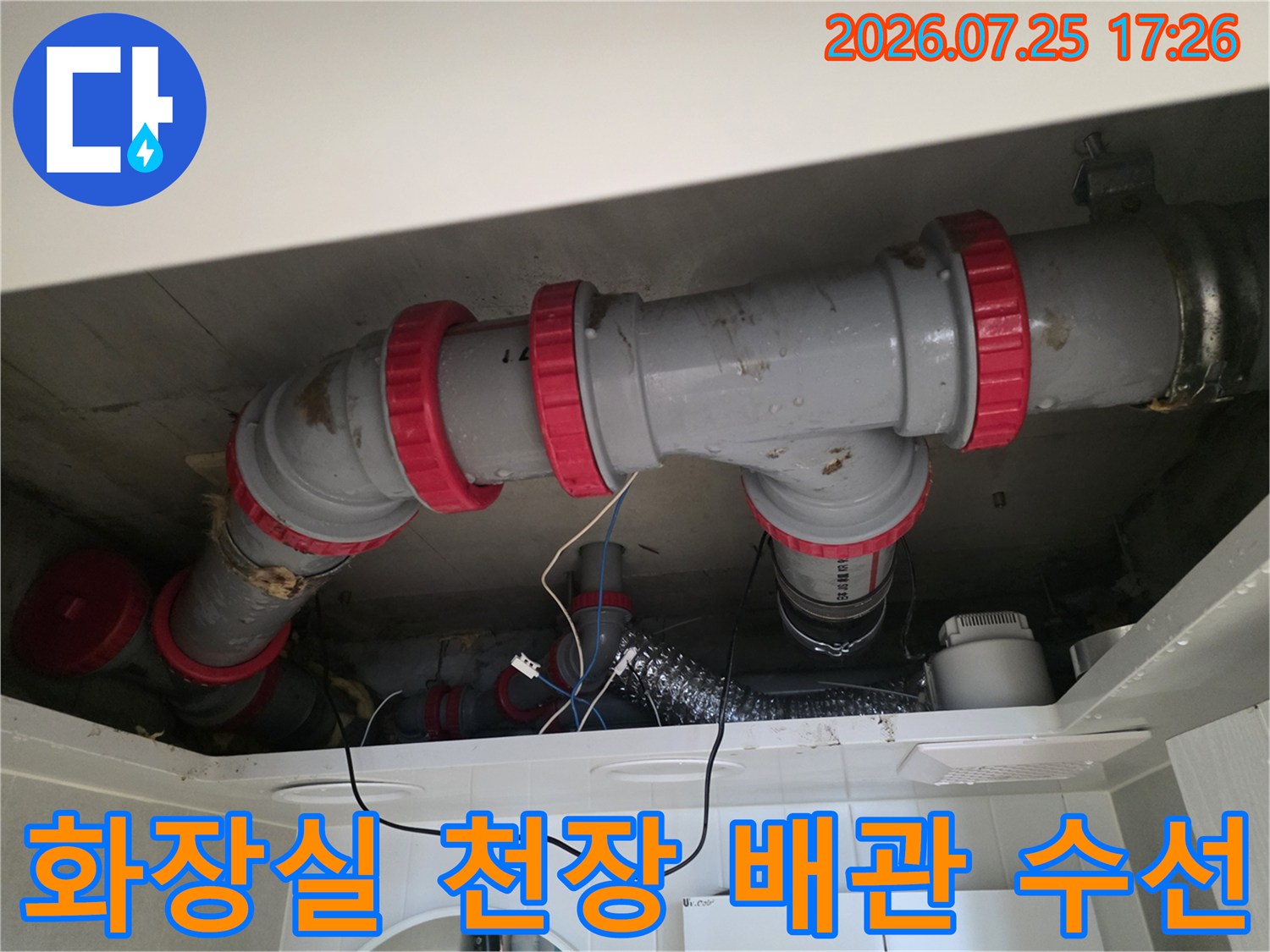 빨간색 연결 부위가 강조된 화장실 천장 배관 수리 현장 사진