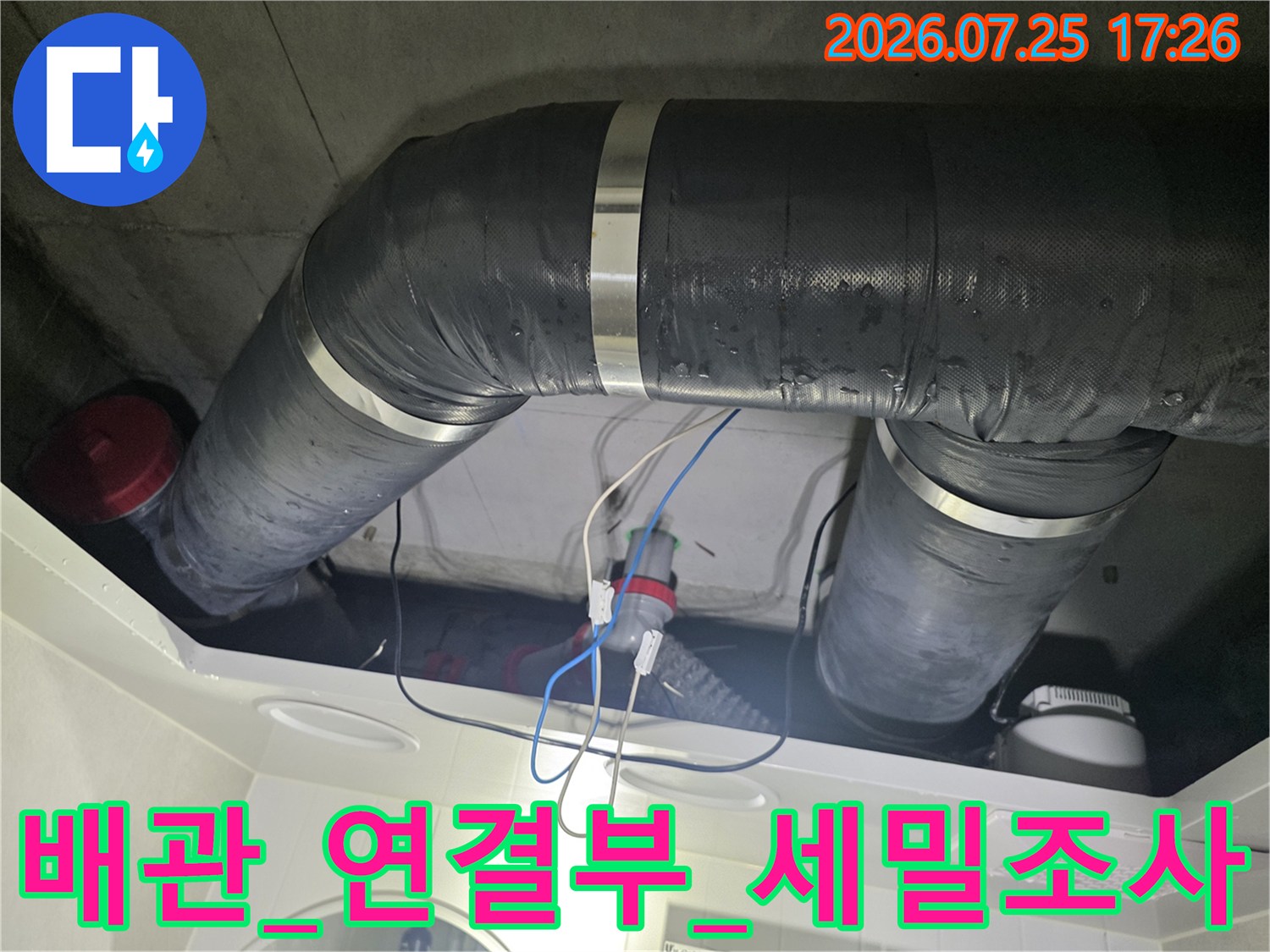 천장 내부의 굴곡진 드럼 배관 연결부를 세심하게 점검하는 과정