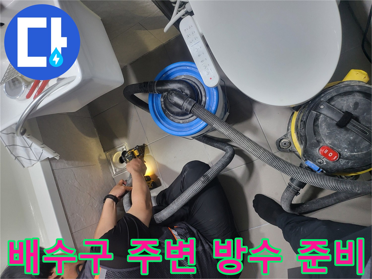 청소 장비를 이용하여 배수구 근처의 흙을 제거하는 공사 현장
