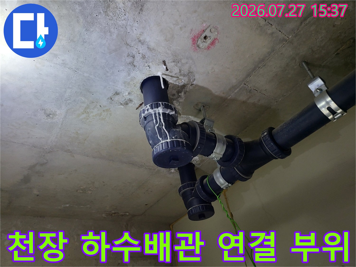 화장실 천장에 설치된 검정색 하수 배관과 연결 조인트 부분-누수 점검 중인 모습