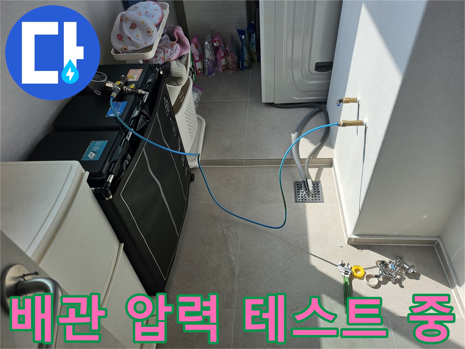 에어컨 배수 점검을 위해 파란색 호스를 연결하여 공기압 테스트를 진행하는 모습