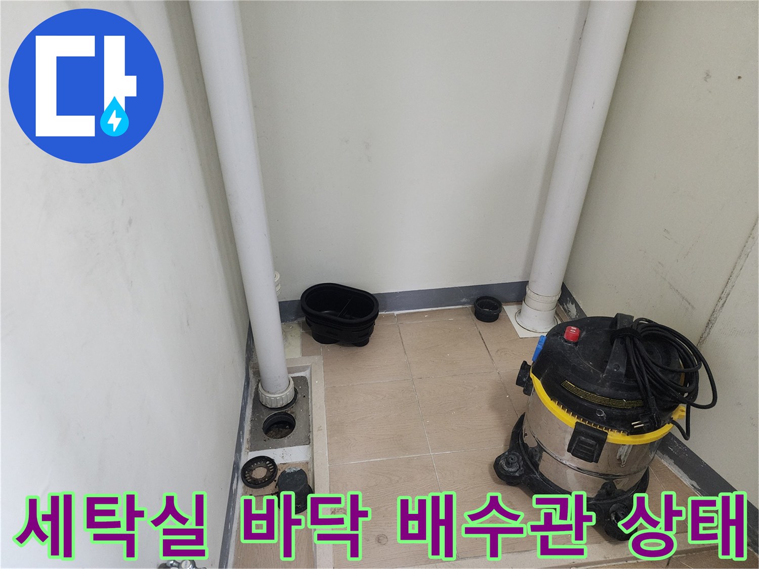 수직-배관과-청소용-장비가-보이는-세탁실-바닥-공사-현장