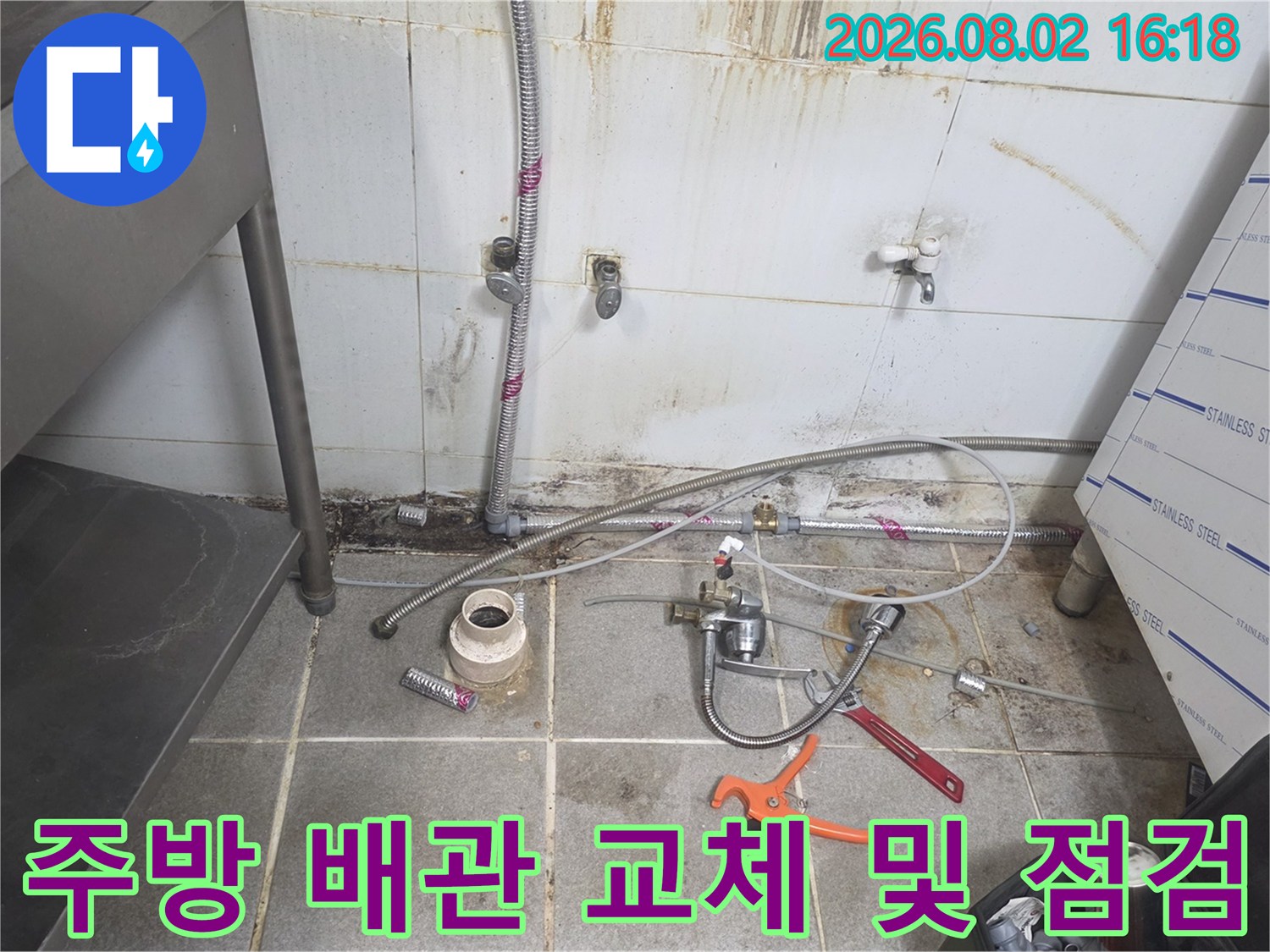 분해된 주방 배관과 수동 렌치 등 공구가 배치된 현장