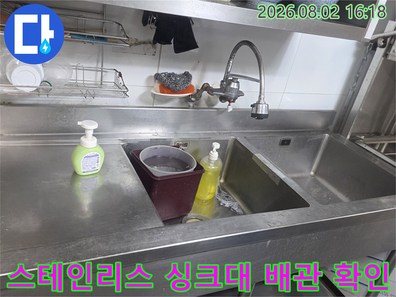 상업소용 스테인리스 싱크대에 설치된 수전과 하부 공간