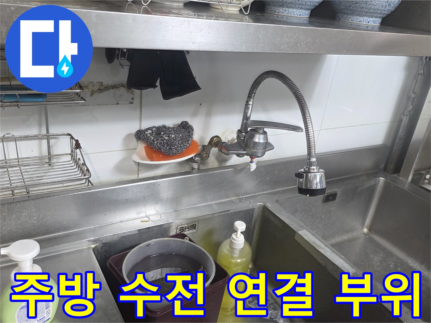 싱크대 아래쪽 수도꼭지와 벽면 배관의 근접 사진