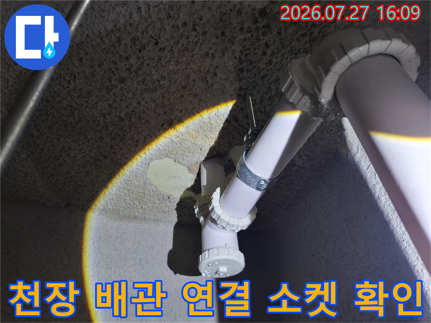 밝은 조명 아래 드러난 지하 천장의 흰색 플라스틱 하수관-연결 부위 상세 모습
