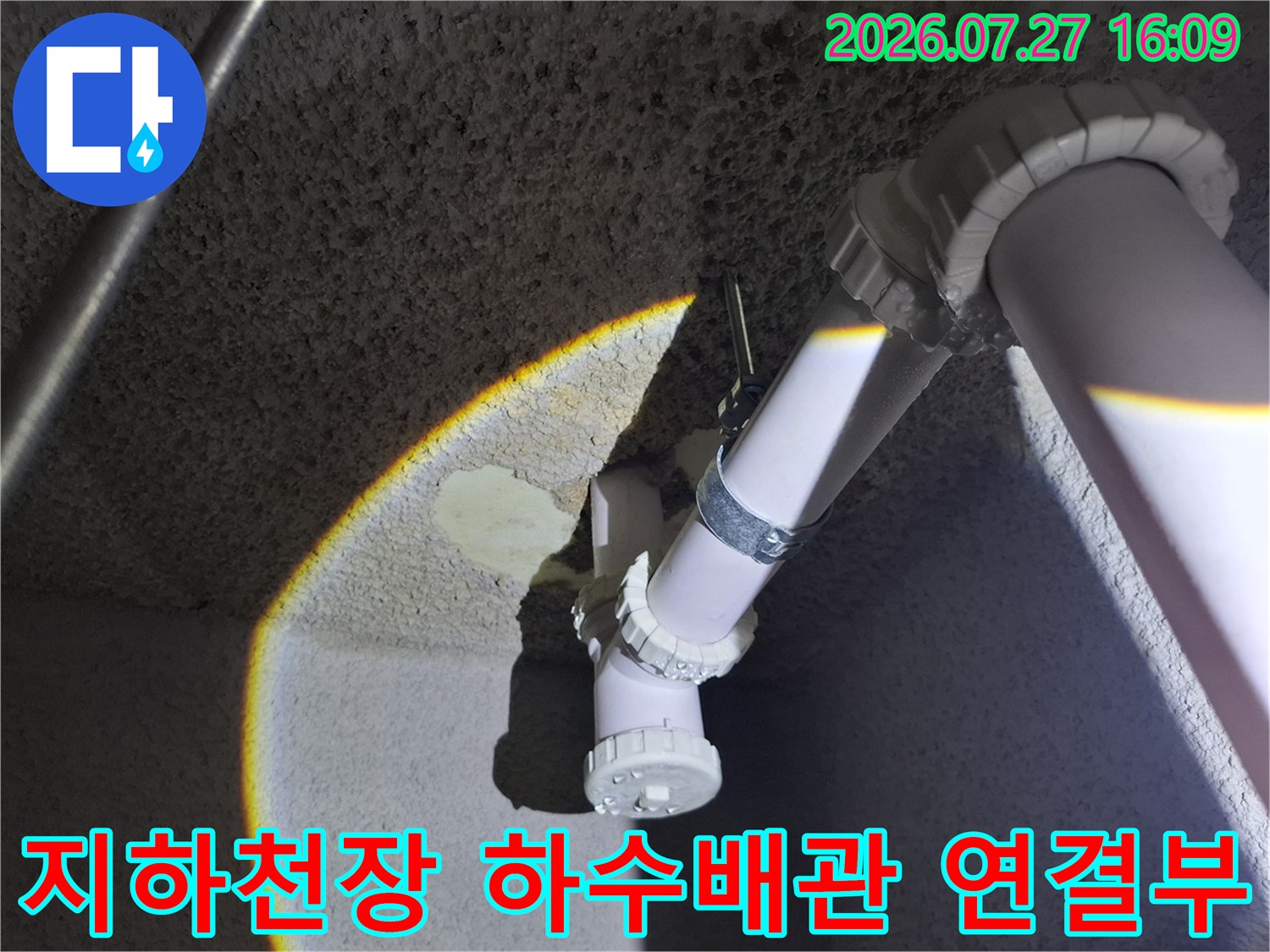 지하층 천장에 설치된 흰색 플라스틱 하수 배관과 엘보 연결 부위-상태 점검 모습