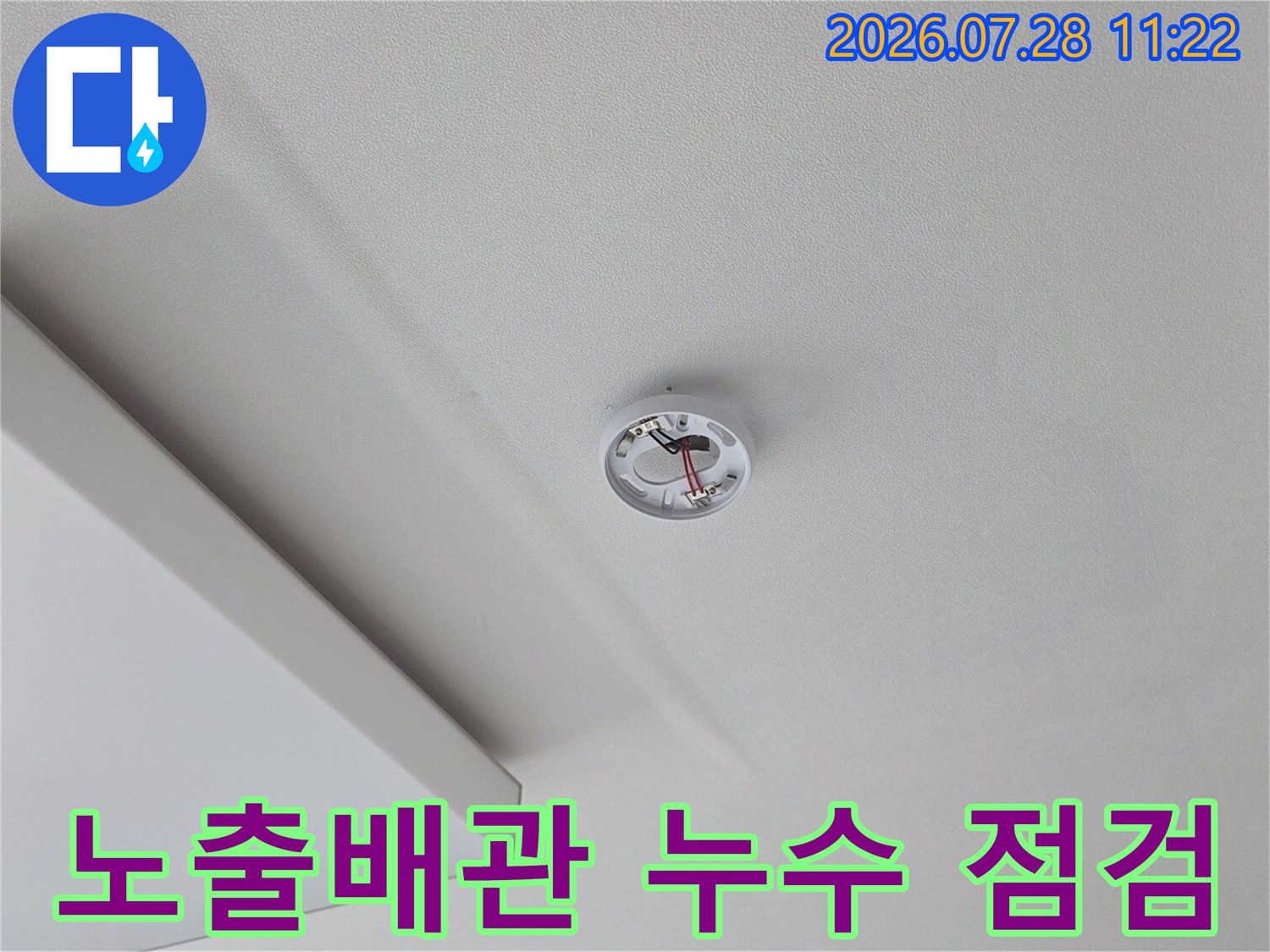 거실 천장에 노출된 배관 연결 부위를 세밀하게 조사하는 장면
