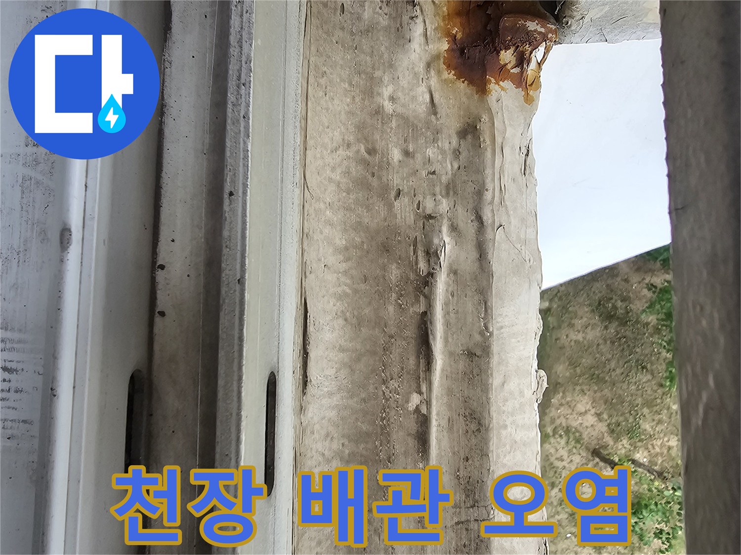 우수관 상단부의 붉은 녹물과 습기로 인한 마감재 변색 부위