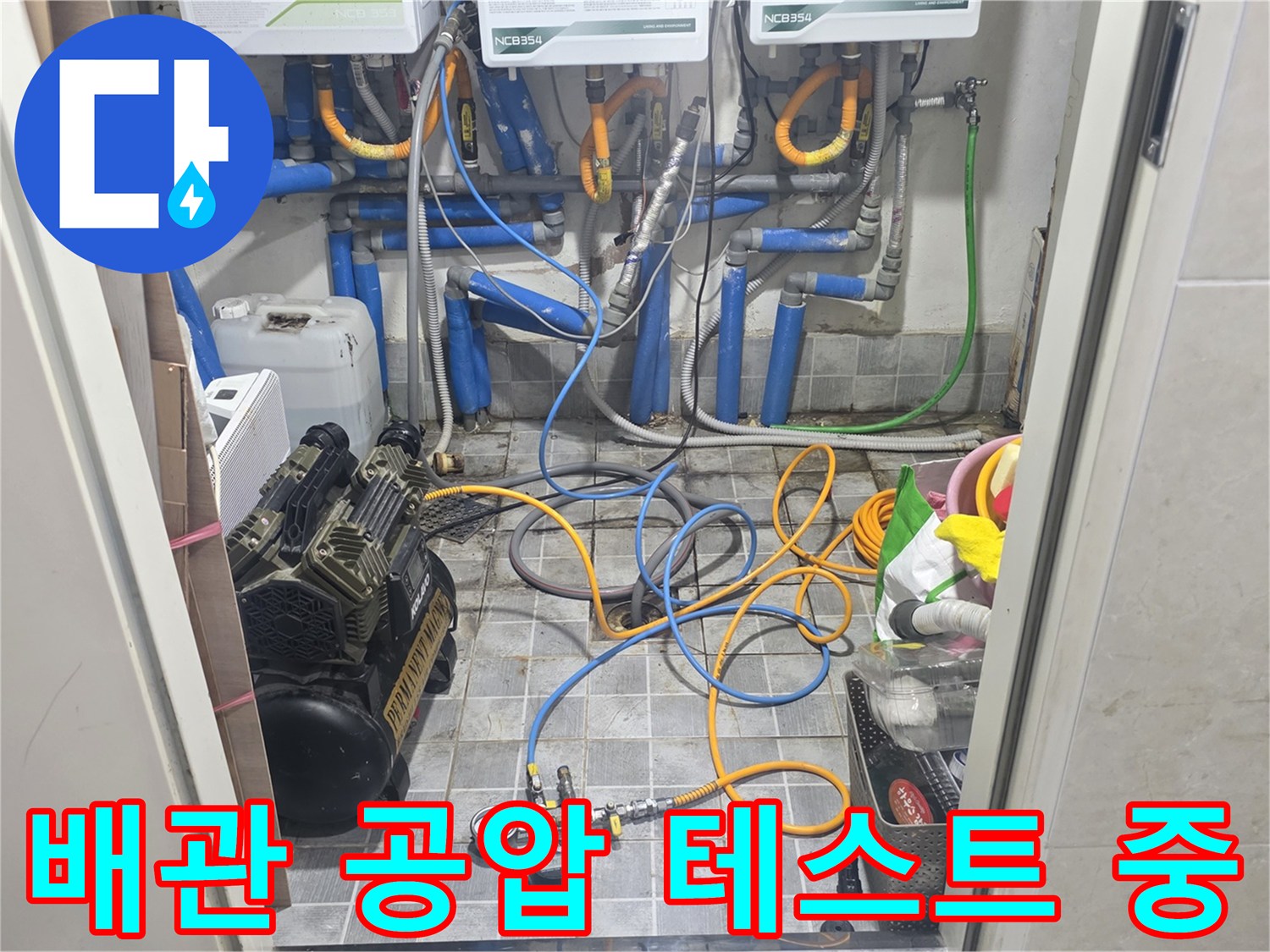 누수 지점을 찾기 위해 배관에 연결된 압력 측정 장비와 호스들