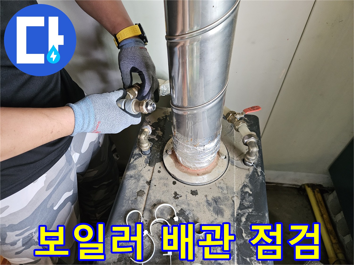 작업자가 보일러 하단 배관을 손으로 만지며 확인하는 사진