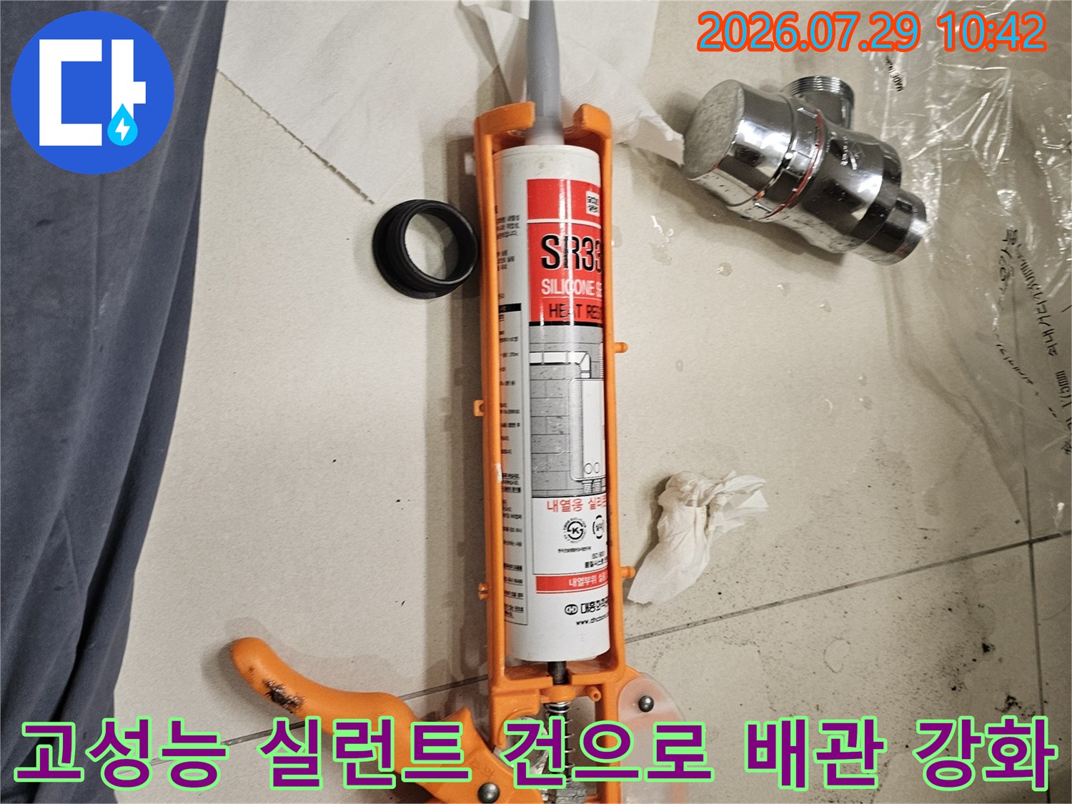 오렌지색 케이스의 전용건을 사용하여 배수 연결부를 보강하는 모습