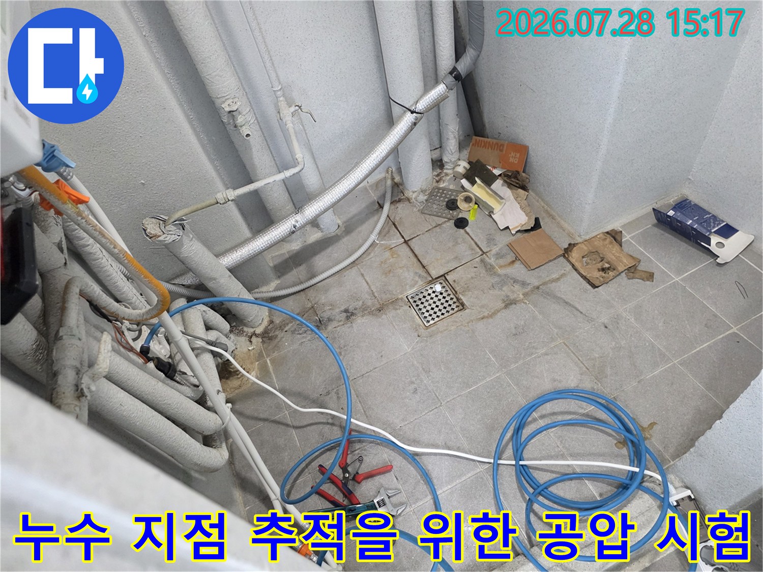노출된 다용도실 배관 시스템과 압력 체크를 위한 호스들이 연결된 모습
