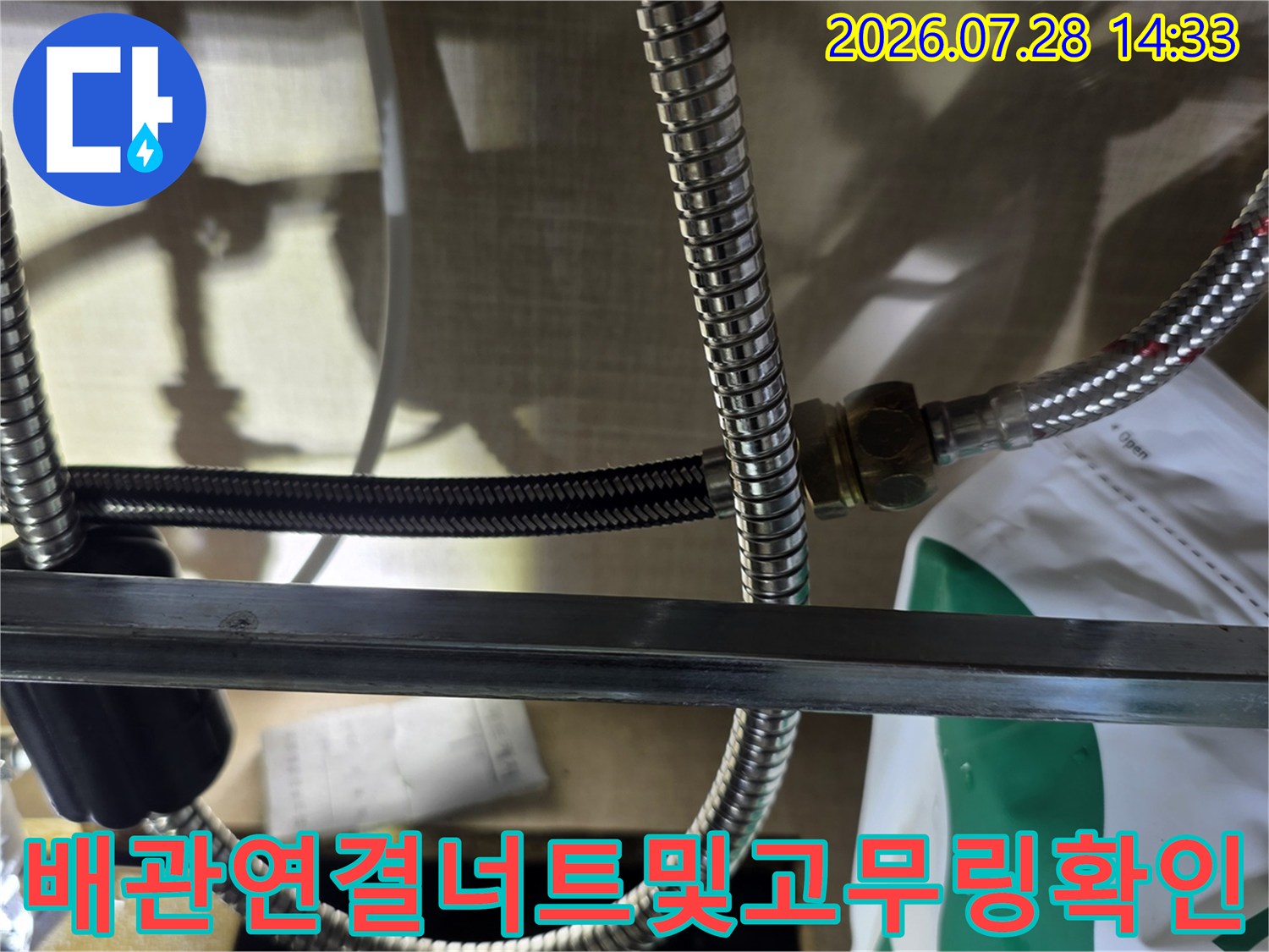 금속제-주름관 배관의 연결 너트와 하단에 분리된 검은색 고무 패킹 사진