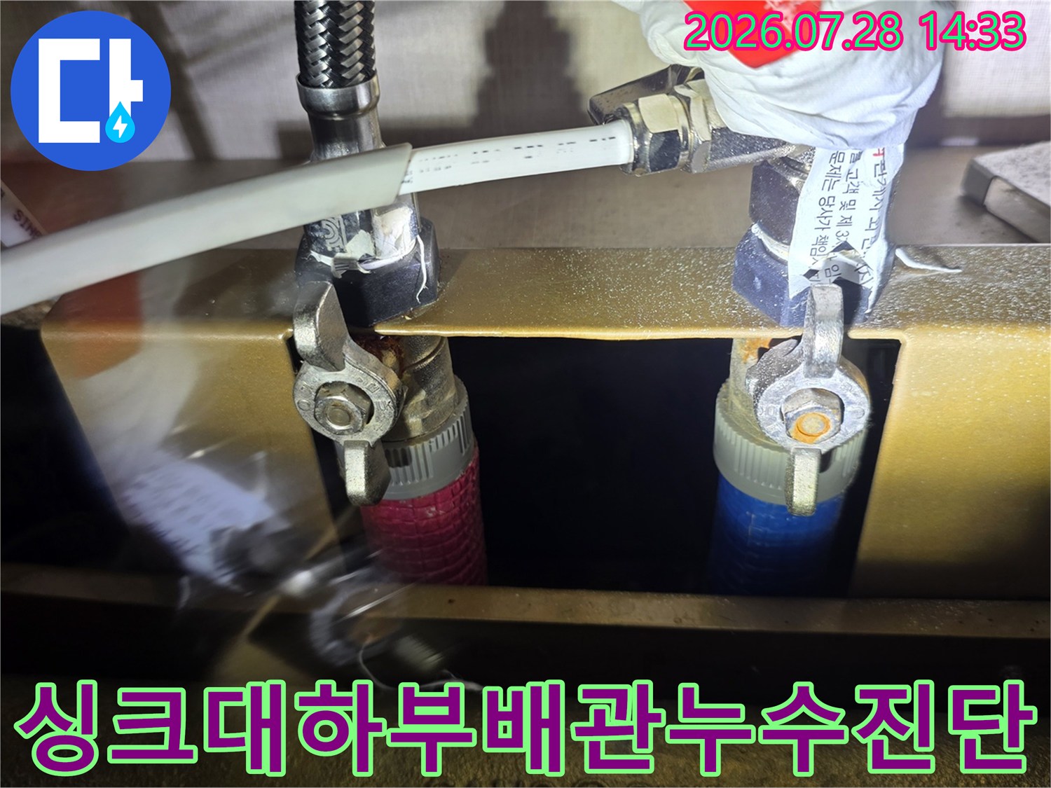 파란색과-빨간색-배관이-연결된-분배기의-너트-부분을-공구로-점검하는-사진