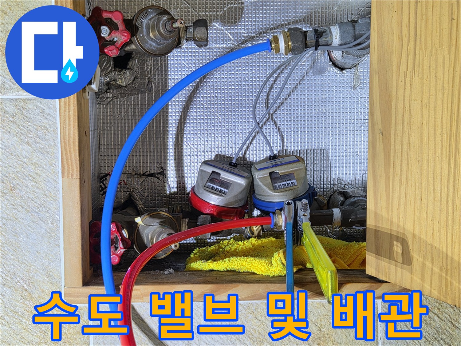 파란색과 빨간색 수도 배관이 계량기에 연결된 상세 사진입니다.