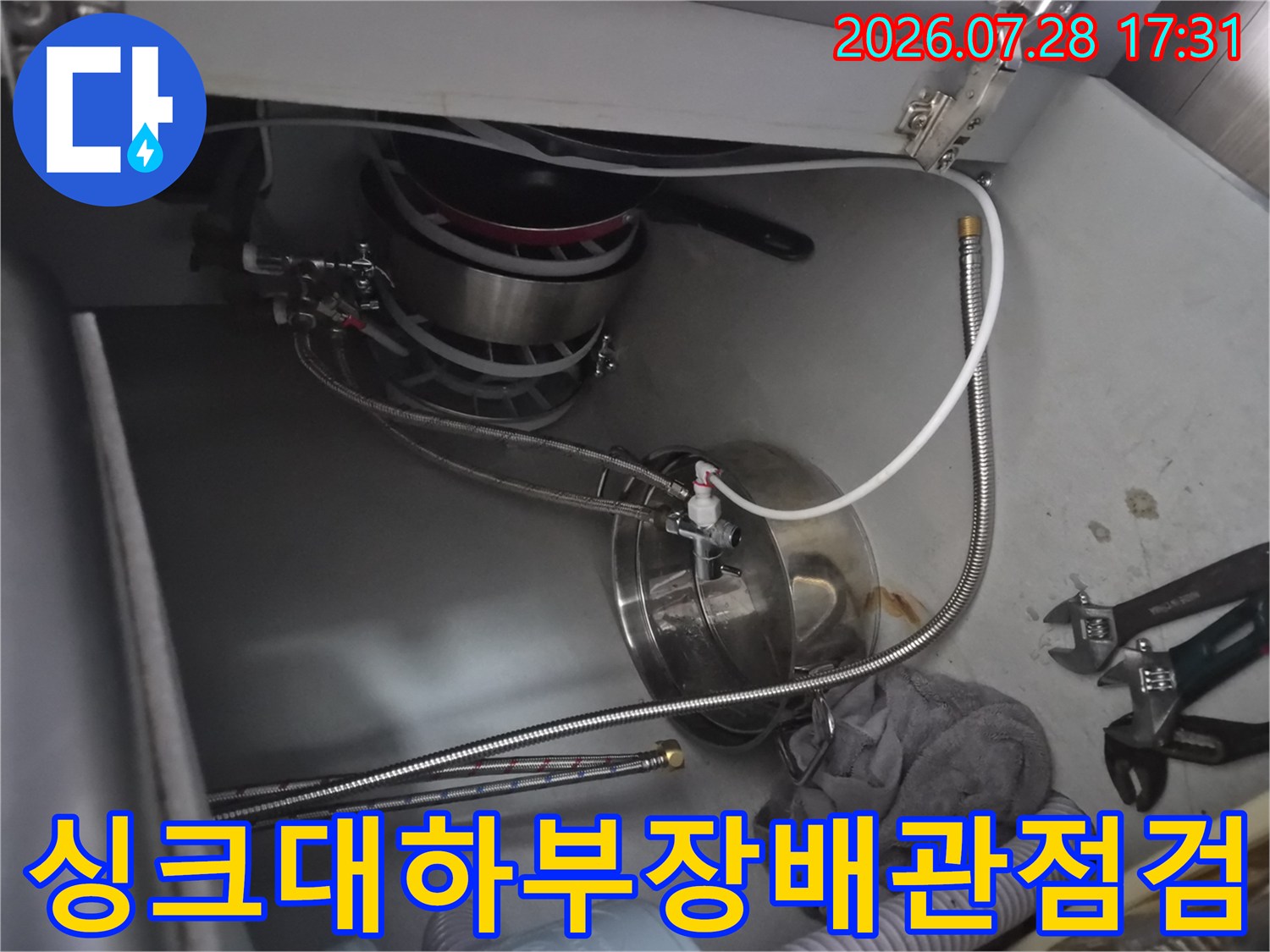 싱크대 하부장의 식기세척기 연결 배관과 수전 부위 점검 모습
