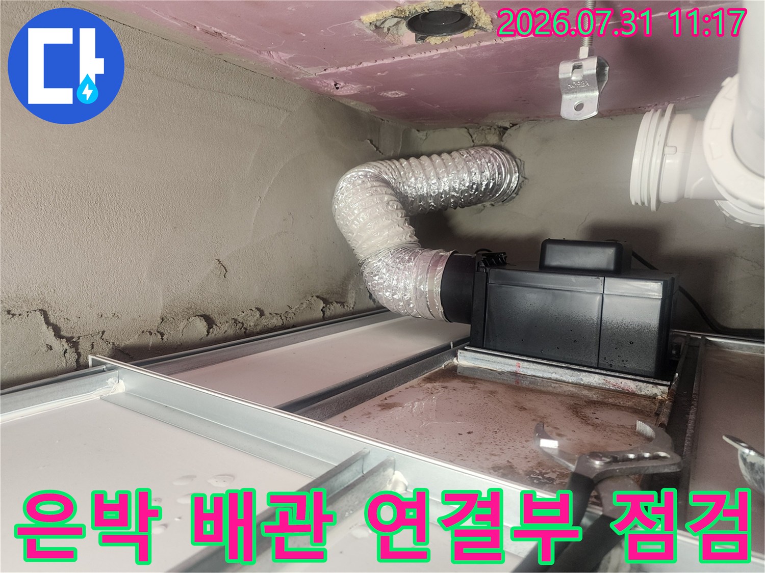 단열재로 감싸진 배관과 하수구 트랩 부근의 노출된 연결 구조물