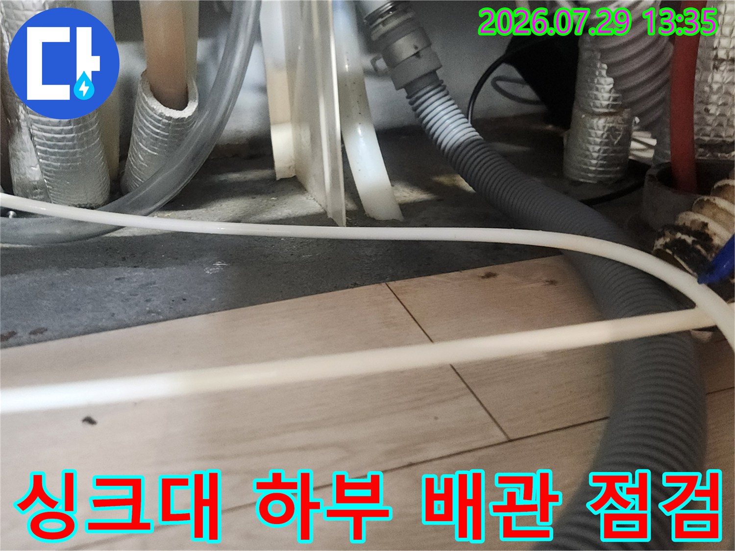 노출된 싱크대 배관과 연결 부위를 점검하는 현장 사진
