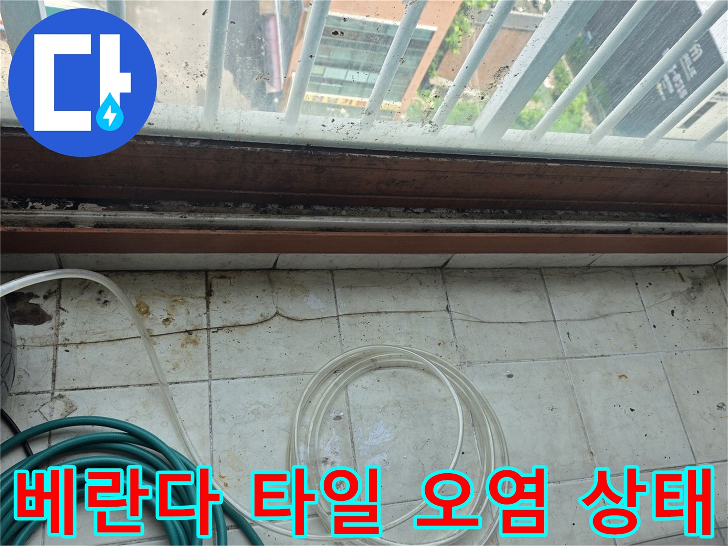 창틀 아래 베란다 타일에 발생한 누수 흔적과 젖은 부위
