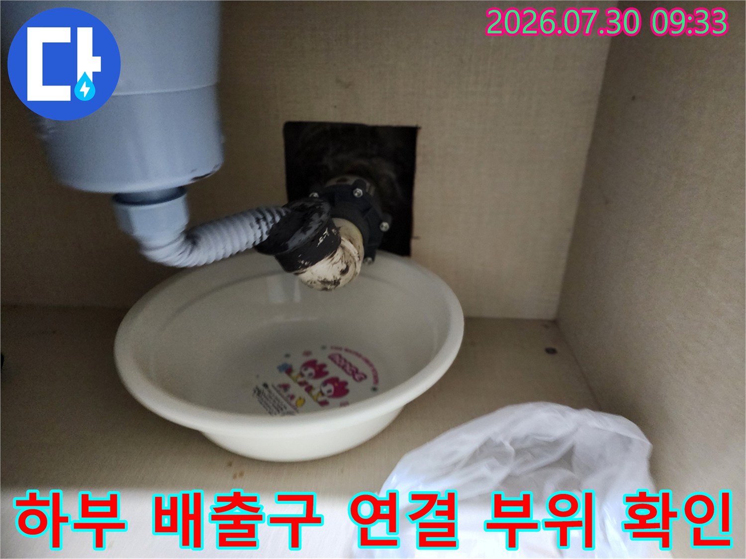 싱크대 아래쪽 노출된 하수 호스의 결합 상태를 상세히 기록한 이미지입니다.