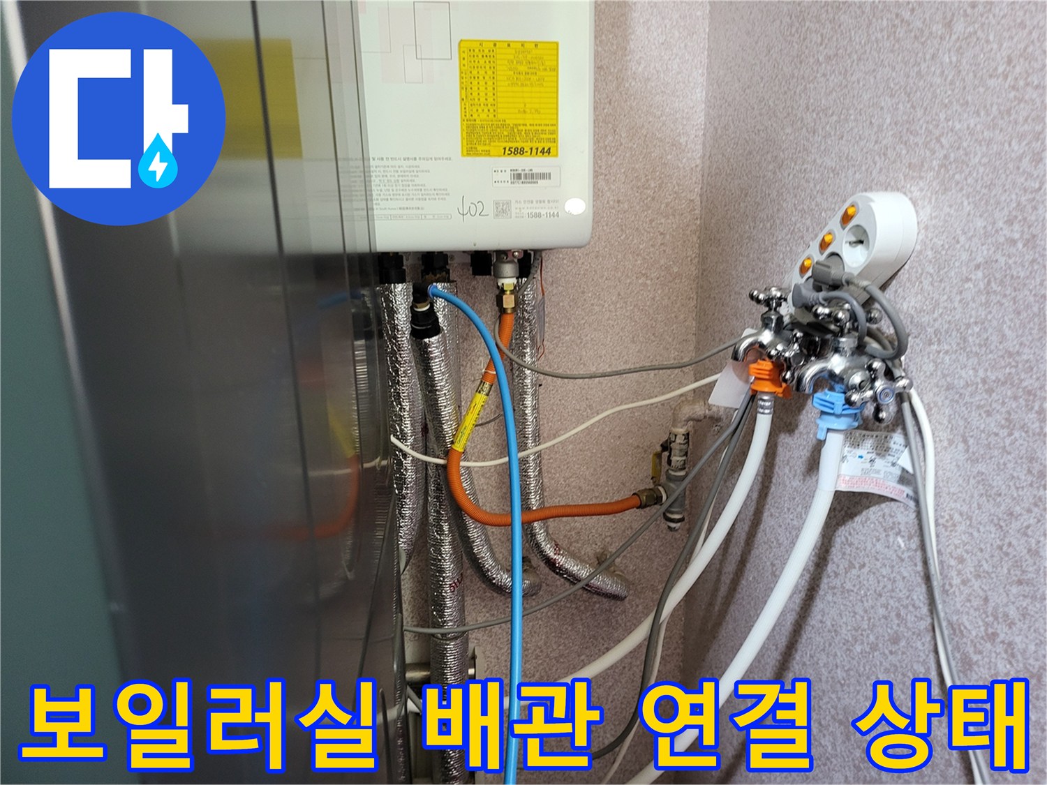 보일러 하단에 복잡하게 연결된 온수 및 냉수 배관 모습