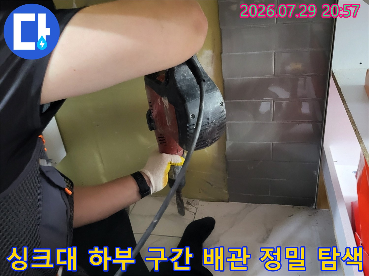 전문가용 청음 장비를 사용하여 싱크대 밑 바닥 속 온수 배관의 파손 부위를 찾아내는 모습