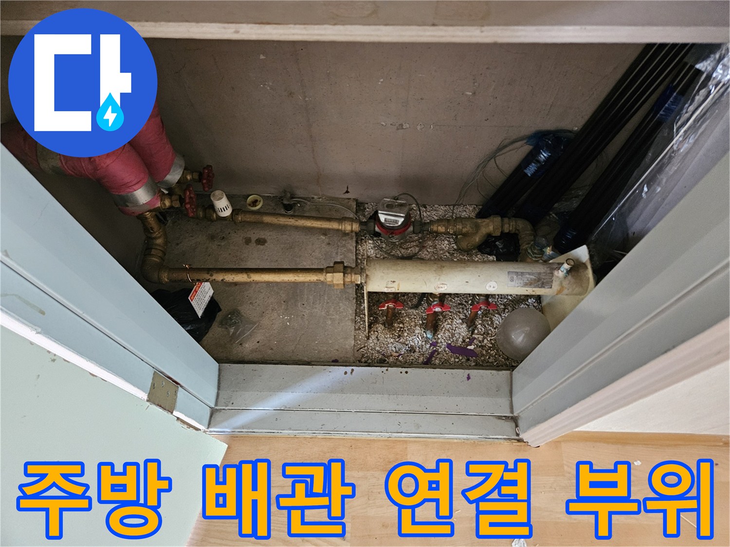 싱크대 아래쪽의 금속 재질 분기 배관과 밸브 부품들
