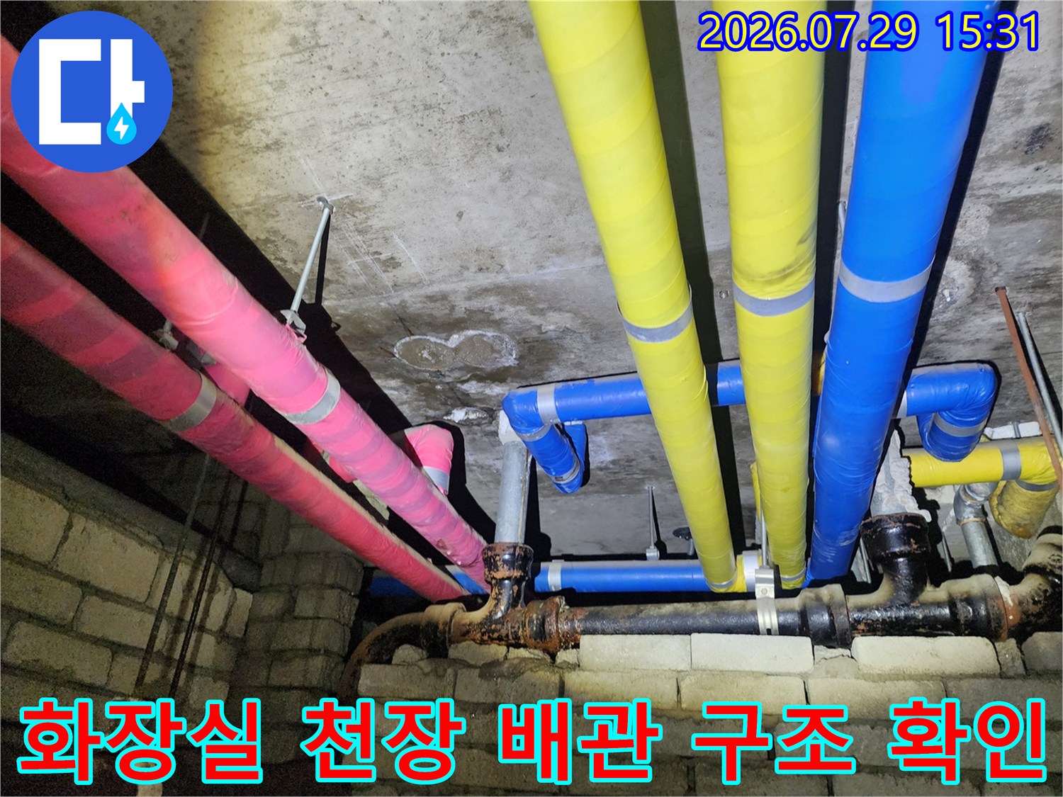 다양한 색상과 재질의 보온재로 감싸인 천장 내부 배관 라인