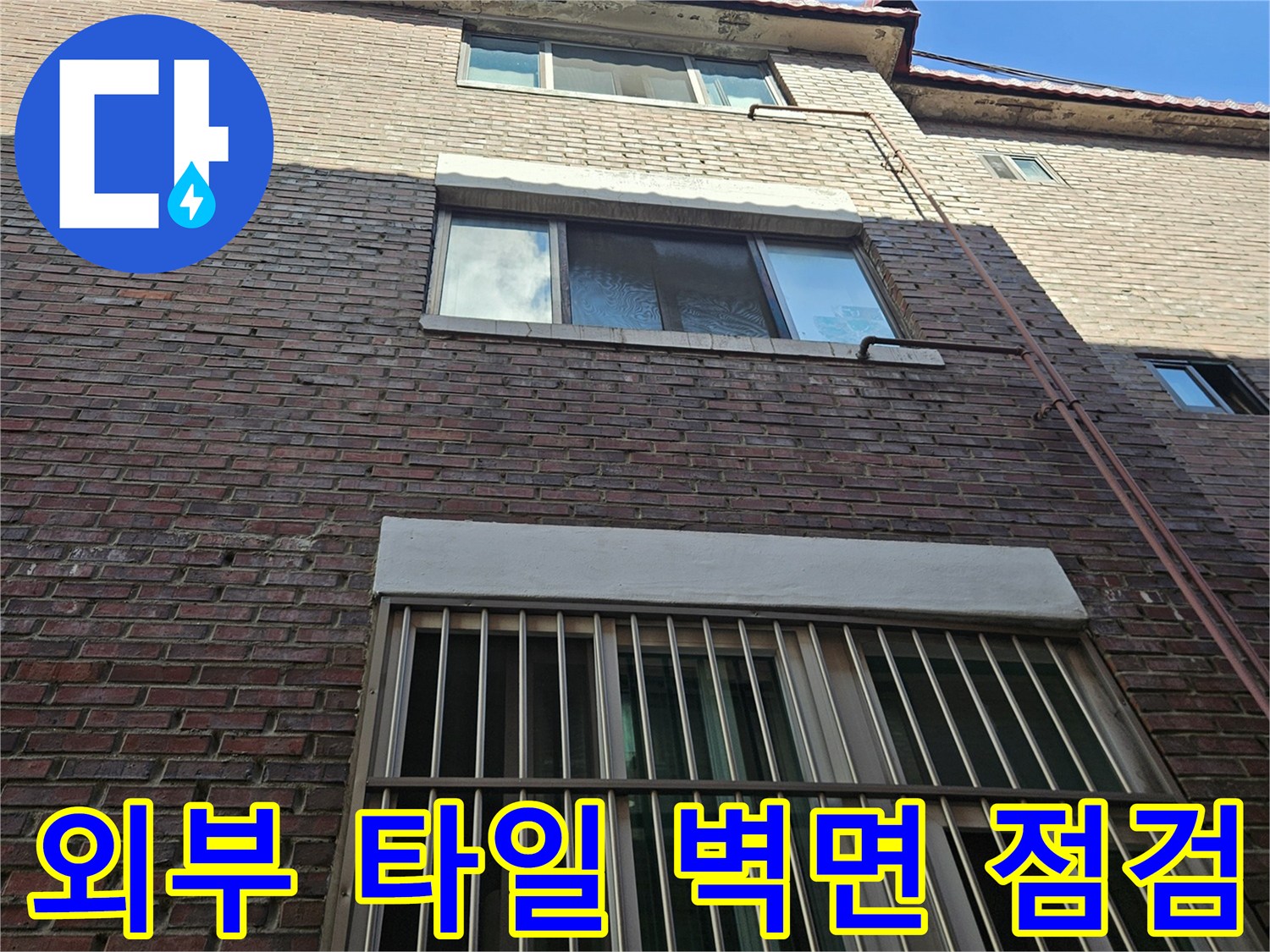 갈색 타일로 된 빌라 외벽과 창문 근처 배관