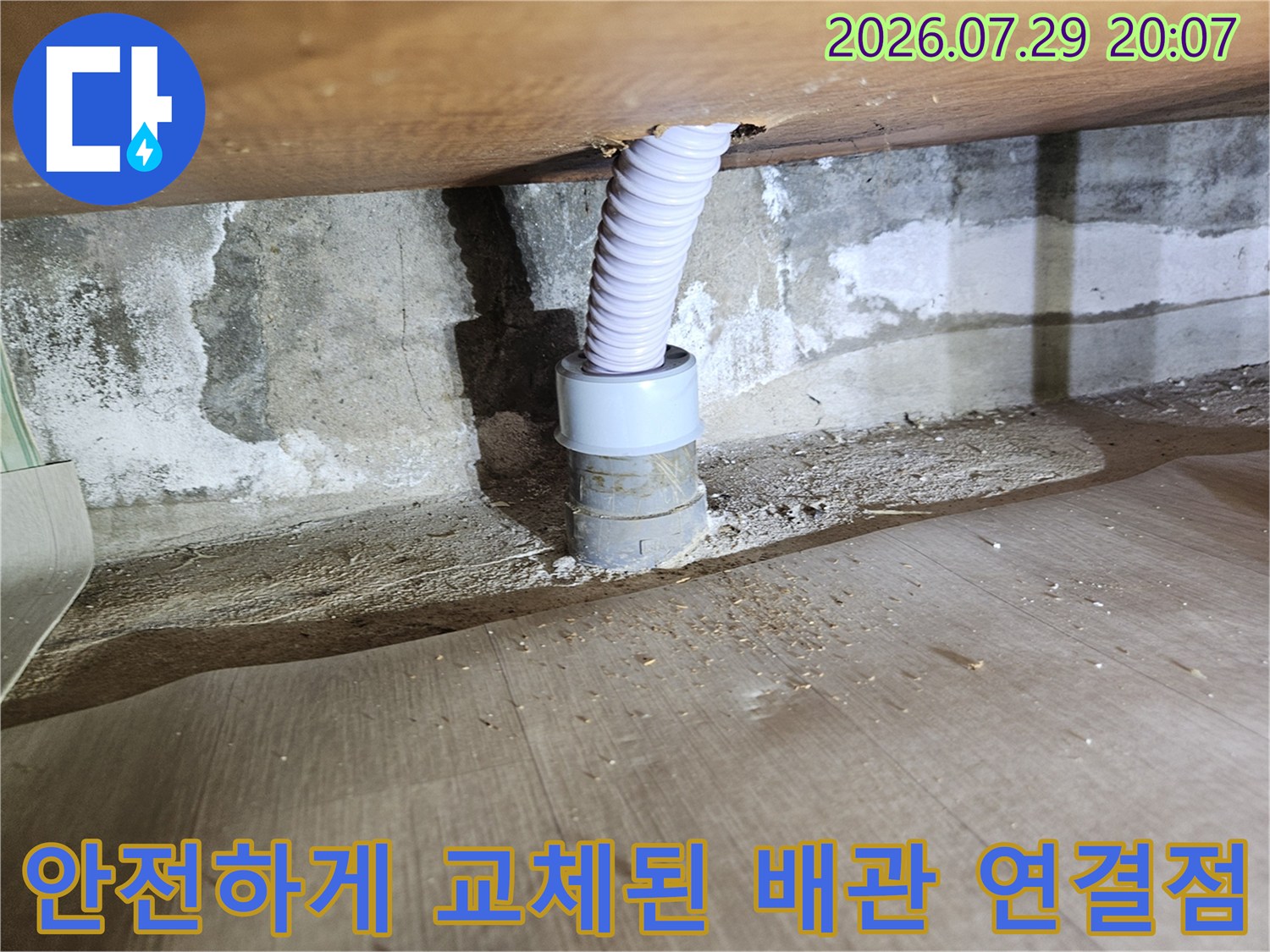 흰색 주름형 관과 파란색 부속품으로 견고하게 고정된 배관부