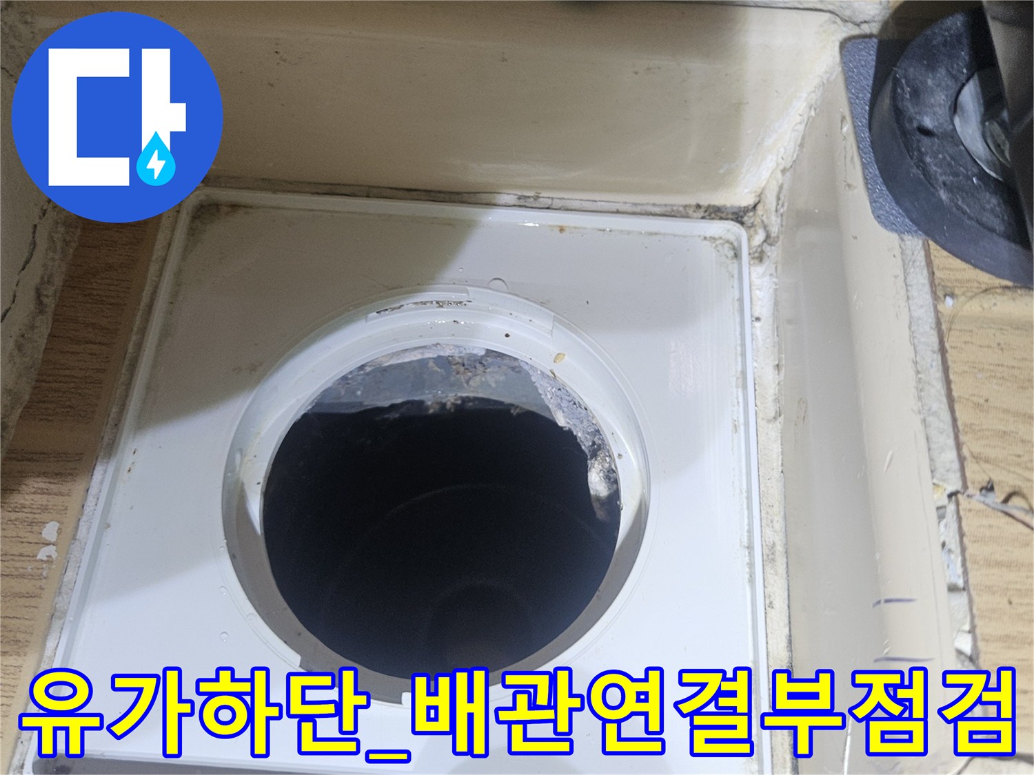 배수구 내부에 노출된 파이프 연결 상태를 촬영하여 누수 가능성을 진단하는 모습