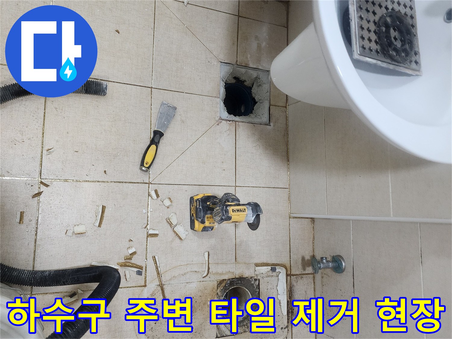 파쇄된 타일 조각들과 드러난 하수관 주변의 작업 모습입니다.
