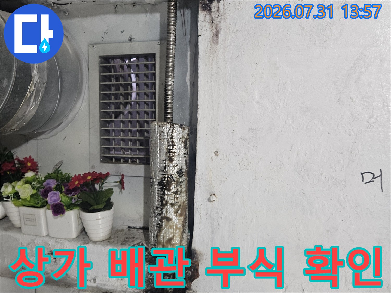 부식된 상가 배관과 수도 계량기가 설치된 벽면 모습