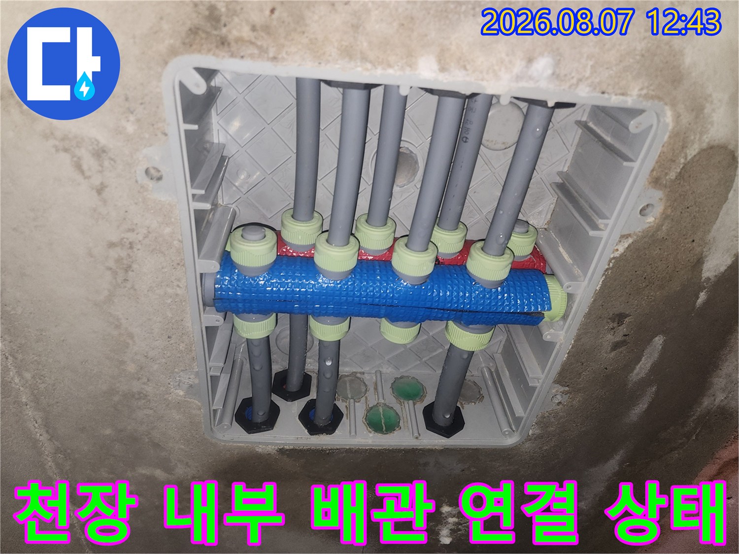 화장실 천장 내부-회색 배관과 파란색 분기 장치의 모습