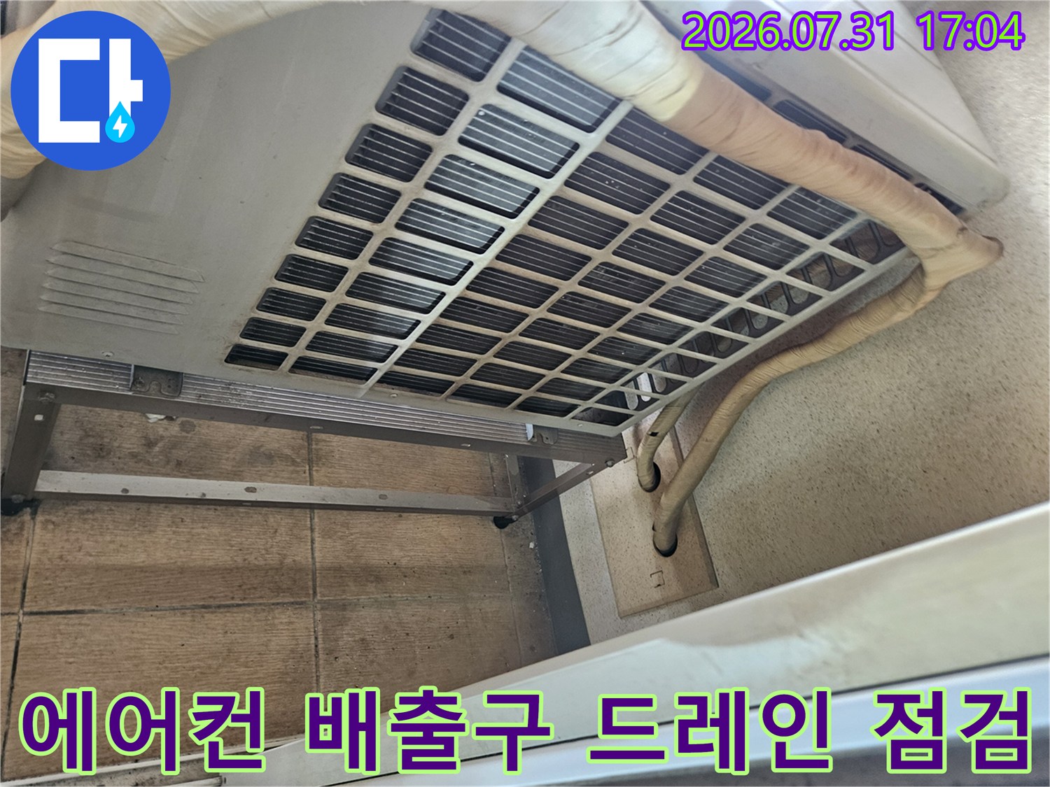 에어컨 하단부의 노출된 드레인 배관과 세척용 트레이 구조물
