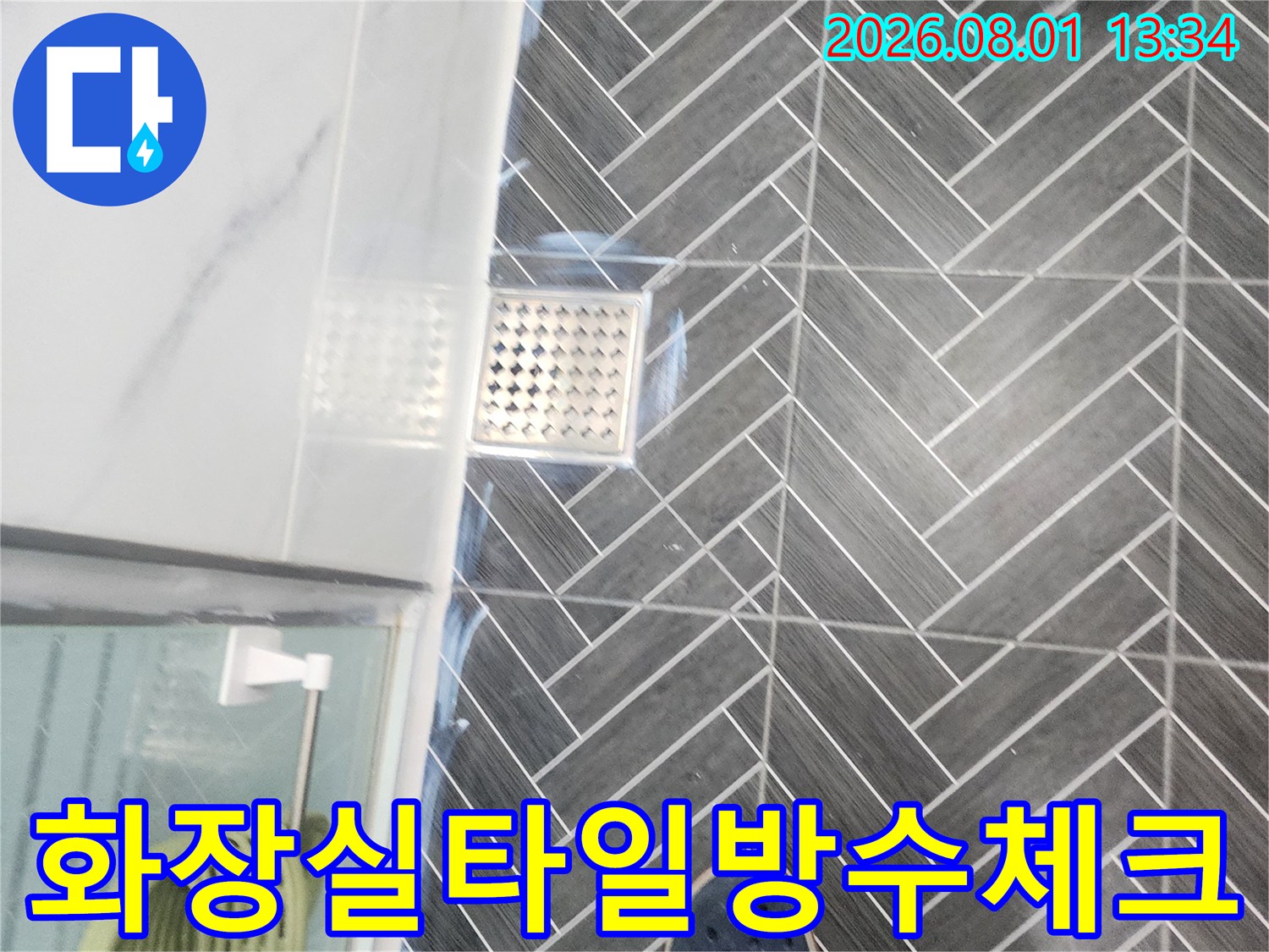 세련된 회색 톤의 타일과 배수구 주변을 촬영한 사진