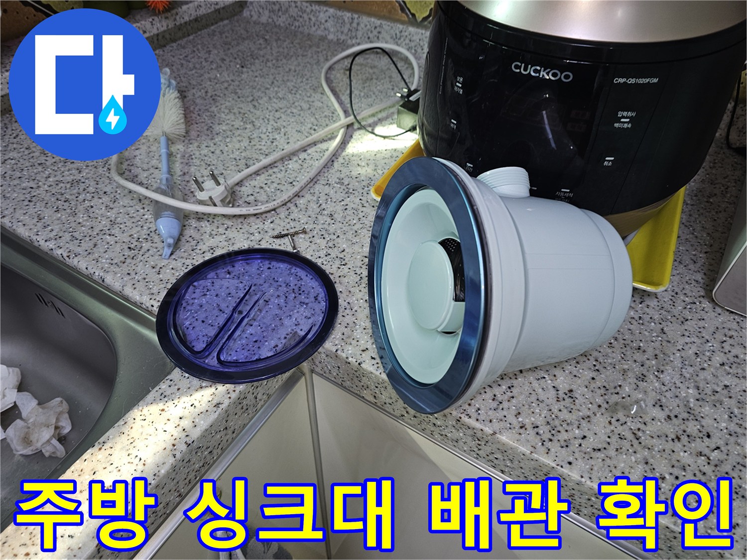 싱크대 하단 배관 덮개와 주변의 작업 환경을 보여주는 사진입니다.