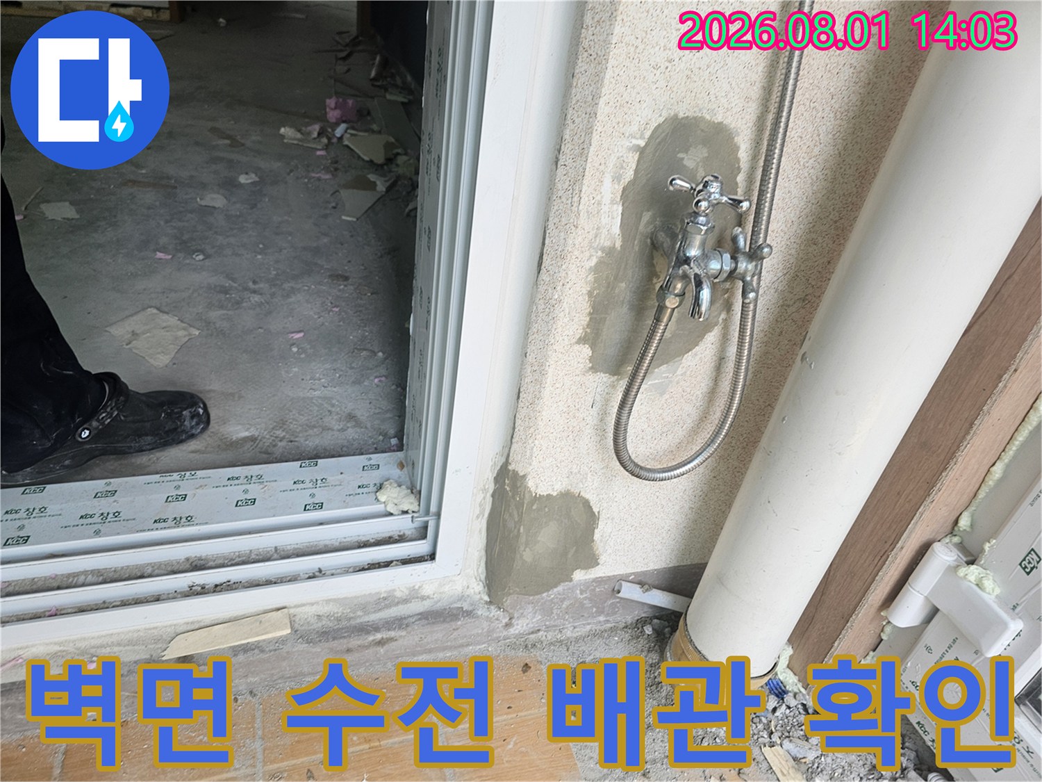 타일이 제거된 세탁실 벽면에서 노출된 직수 수전과 연결부의 상태를 점검하는 모습