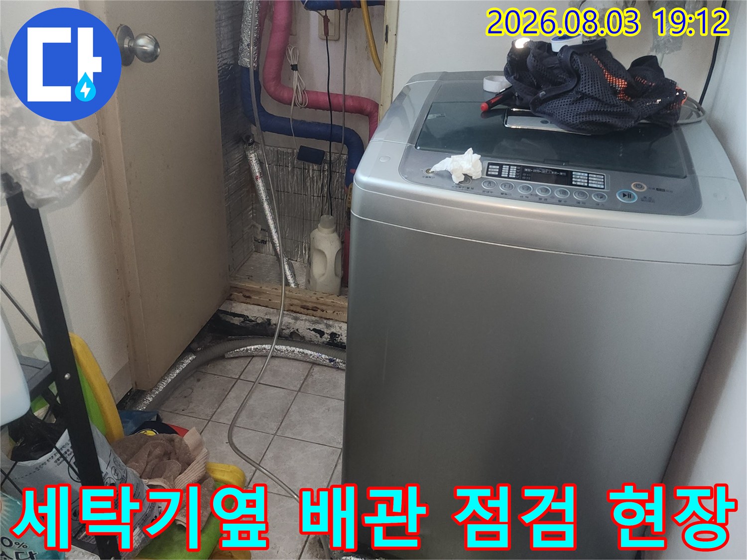 세탁기 옆에 배치된 배관과 주변 방수 작업이 필요한 공간의 모습
