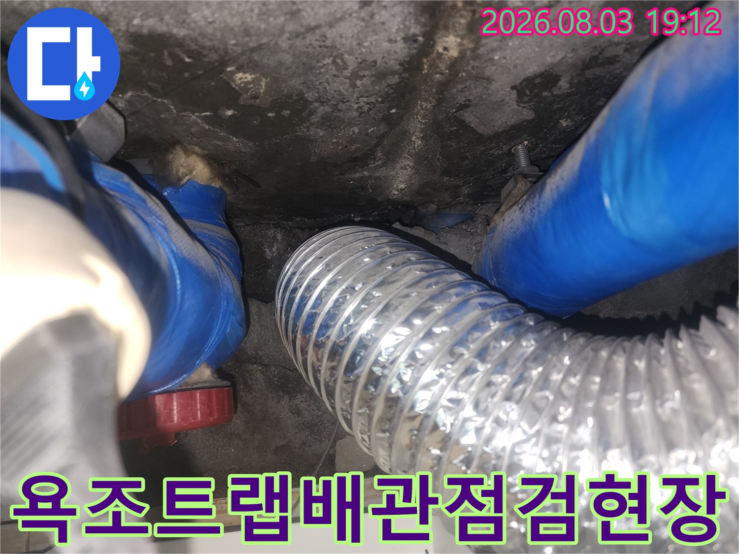 욕조 아래 배수 트랩과 은색 유가관이 연결된 누수 점검 부위