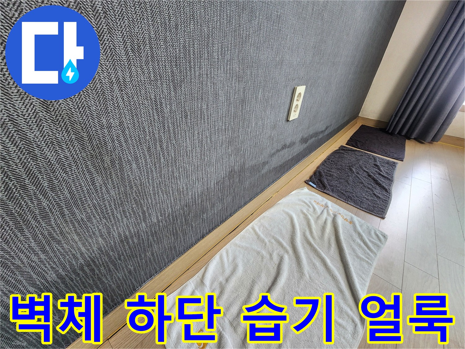 벽지 하단에 나타난 젖은 흔적과 콘센트 주변의 변색 상태