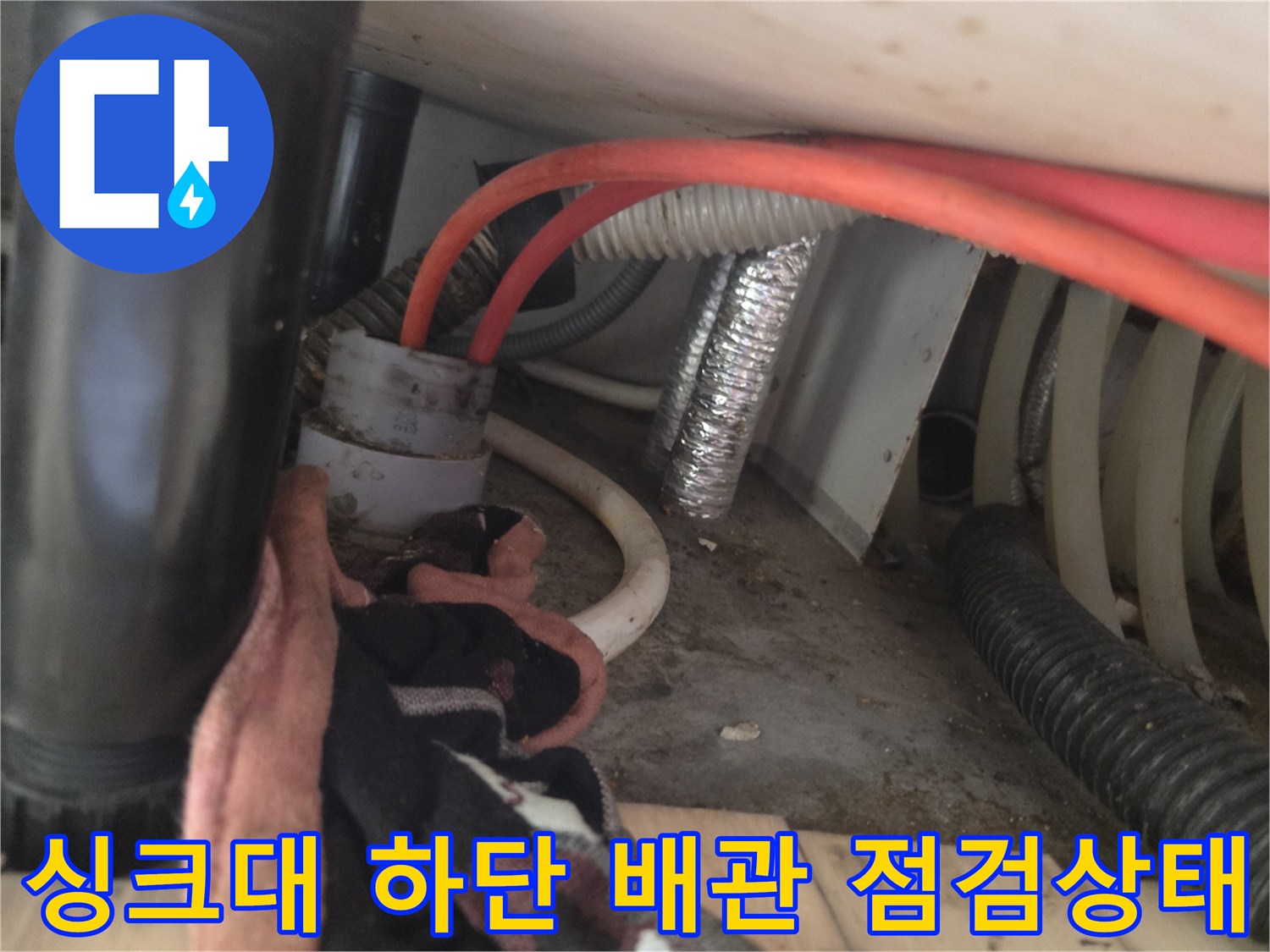 싱크대 아래쪽 붉은색 호스와 흰색 자재 연결 부위